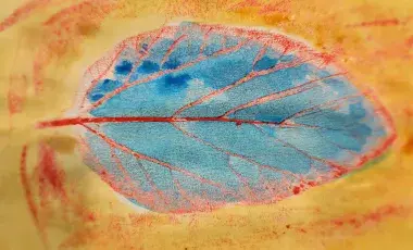 Leaf rubbing with blue and red crayons and yellow watercolor paint
