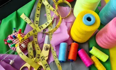 Sewing tools and fabric cut from a pattern.