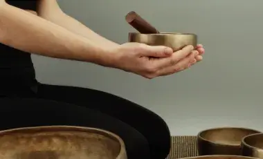 Hands cup a singing bowl