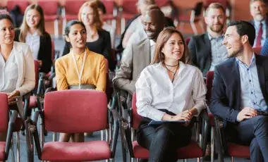 A group of people sitting in chairs, lecture style. 