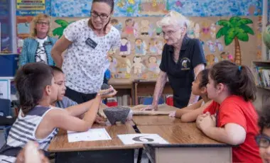 Educators interact with students in a classroom