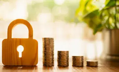 Stacks of coins next to a padlock