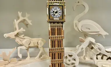 A variety of 3D wooden puzzles of animals, a building and a vehicle.