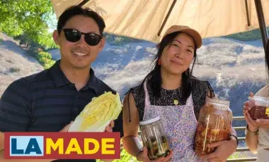 three people holding up jars and vegetables