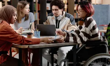 Teens studying at a table together.