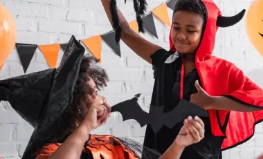 Kids in Halloween costumes play with Halloween toys