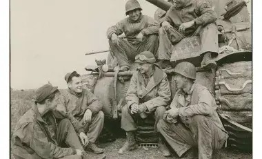 Ernie Pyle talks to tankers from the US Army's 191st Tank Battalion courtesy of the US Army Center for Military History.