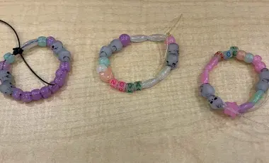 Three bracelets made of colorful beads on a table