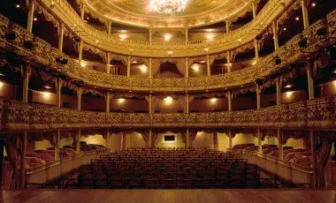 A photo of an empty opera house taken from the point of view of the stage. 