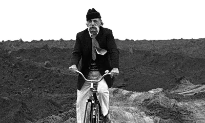 historic photo of person riding bike on dirt road