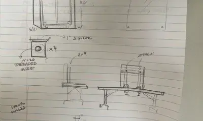 hand holds pencil near drawing on lined paper