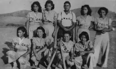 Group portrait of the Aztecas, a girls’ baseball team based in Pacoima, with their manager
