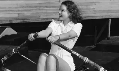 Ann Morris, Metro-Goldwyn-Mayer actress, demonstrates how she exercises on the rowing machine in the studio gym