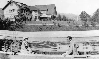 Mary Pickford and Douglas Fairbanks Sr. canoe in the swimming pool of their estate, Pickfair