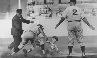 Coach Leo Durocher signals safe as Dodger Maury Wills slides under the tag of Giants third baseman Jim Davenport for yet another stolen base in 1962