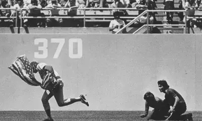 Cubs outfielder Rick Monday stops two protestors from lighting an American flag on fire during a game at Dodger Stadium in 1976