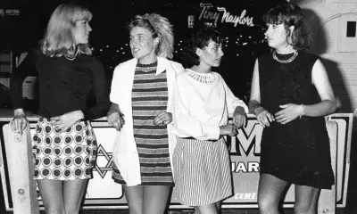 Bandmates from the Bangles hold cigarettes outside