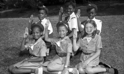 Local Girl Scout Juniors and Cadettes demonstrate the Girl Scout Sign, circa 1964.