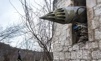 missile protrudes from window of brick building 