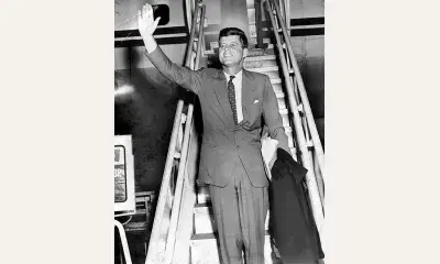 John F. Kennedy at the bottom of stairs from a plane