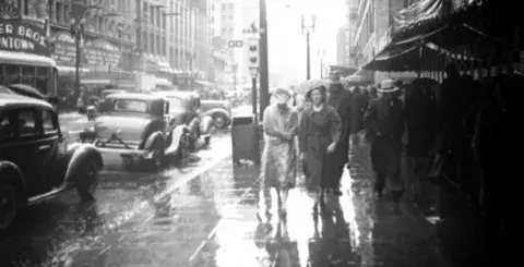 Walking in the rain by the Warner Downtown