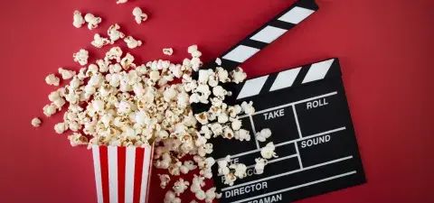 popcorn and film clapper on a red background
