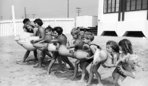 Children at the beach with floatie toys