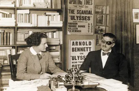Joyce with Sylvia Beach at 12 rue de l’Odéon - 1922 known by the “Scandal of Ulysses” poster. unknown photographer; source: The Poetry Collection of the University Libraries, University at Buffalo, The State University of New York