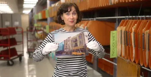 Wendy holding up a photo from the Jay More collection