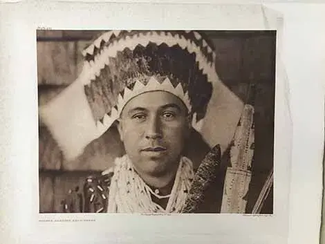 Plate 455 Tolowa Dancing Head-Dress.  Native American Tolowa man wearing a head dress, photographed looking straight into camera with plain expression