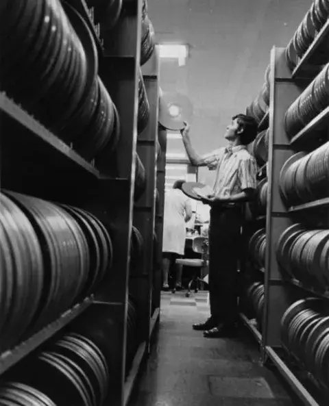 A man retrieving, two reels of film