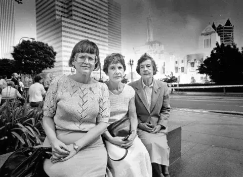 Three librarians are pictured in front of the burning Central Library 