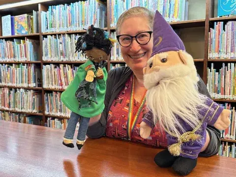 Mara Alpert showing off the Librarian and Wizard puppets