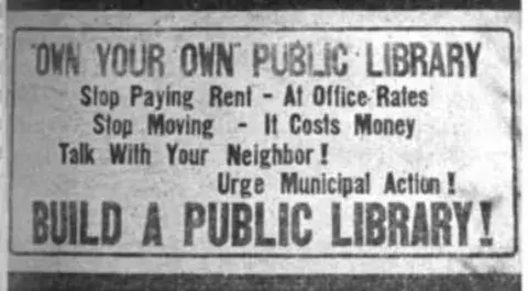 Message reads "Own Your Own Public Library. Stop Paying Rent. At Office Rates. Stop Moving. It Costs Money. Talk With Your Neighbor! Urge Municipal Action! Build A Public Library!"