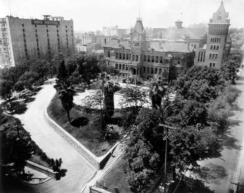 An aerial photograph of the Teacher's college building in the background with the brick building of the Bible Institute on the left.