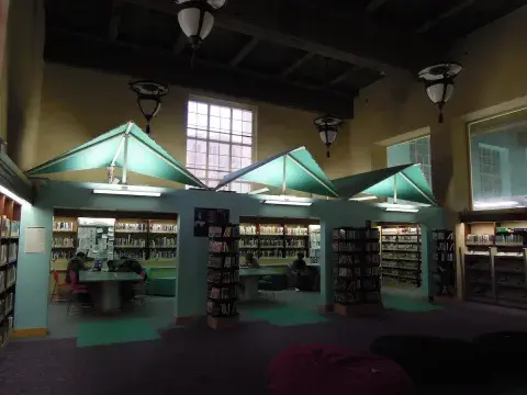 Teenscape book stacks with patrons sitting at the tables.