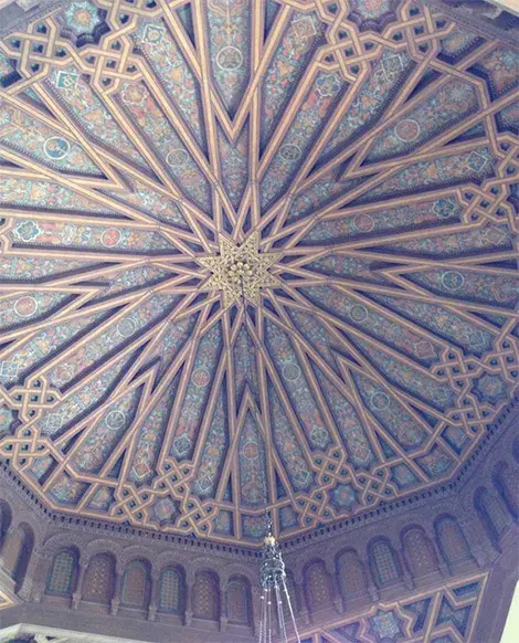 Painted mural with an 8 pointed star in the middle on the ceiling of the library reading room..