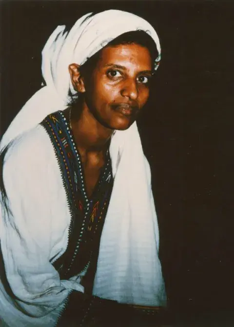 A woman with a white garment covering her head.