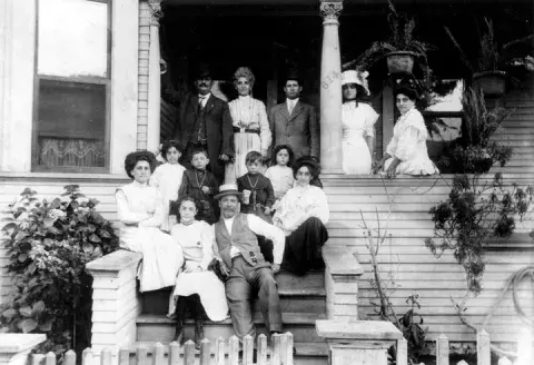 A family on the steps of their home.