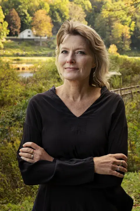 Jennifer Egan arms crossed in a black dress 