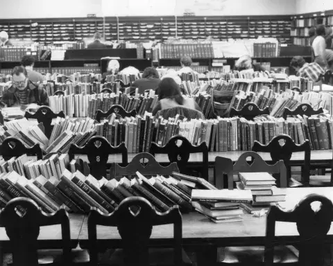 Piles of books shelved on top of reading tables 