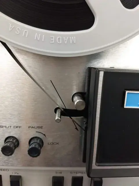 Audio tape going through guide roller into control box.