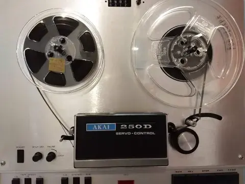 Reel to reel player with the audio tape being played.