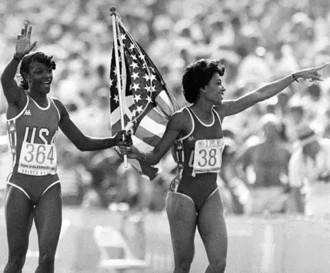 Two women holding an American flag.