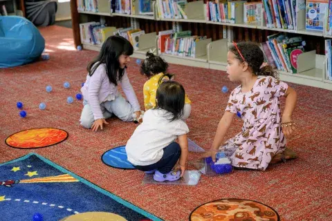 Kids play together on the floor of library