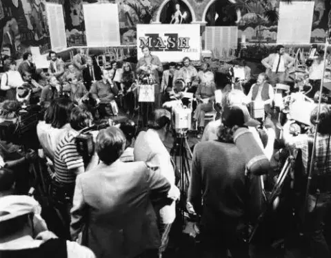 Alan Alda, at the podium, addresses production crew, reporters and guests at the wrap party at 20th Century Fox studios
