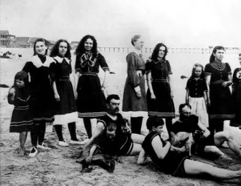 A group of bathers - men, women and children - pose at the water