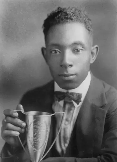 A student poses with a trophy