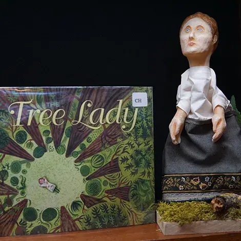 the book The Tree Lady next to a puppet of a character from the book