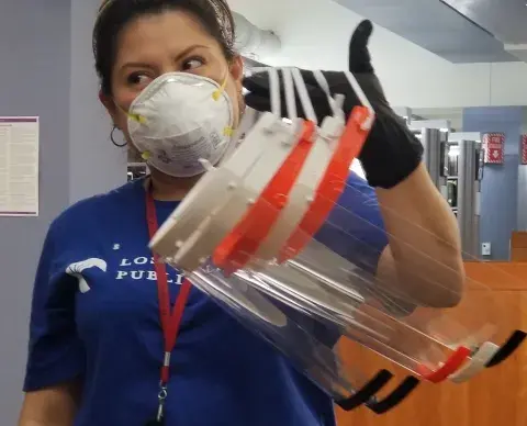 staff member holding an arm load of facemasks